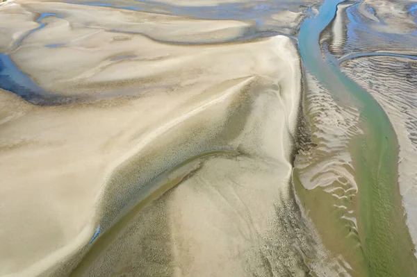 Aerial landscape of ocean at low tide showing sandbanks and seawater in abstract patterns. Cape Hillsborough, Queensland, Australia