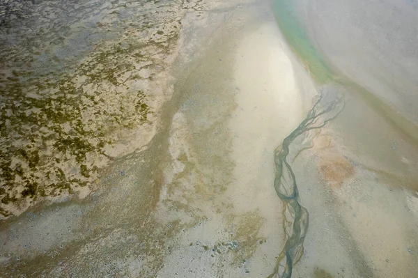 Aerial landscape of ocean at low tide showing sandbanks and seawater in abstract patterns. Cape Hillsborough, Queensland, Australia