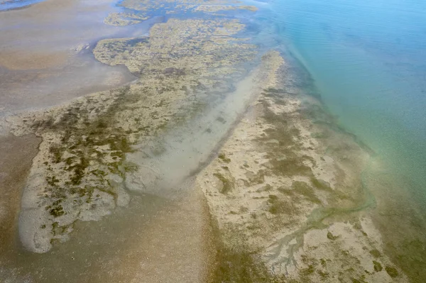 Aerial landscape of ocean at low tide showing sandbanks and seawater in abstract patterns. Cape Hillsborough, Queensland, Australia