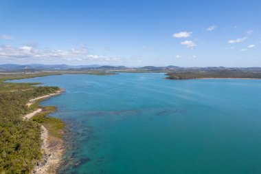 Mavi okyanuslu ve gökyüzü karaya bakan insansız hava aracı manzarası