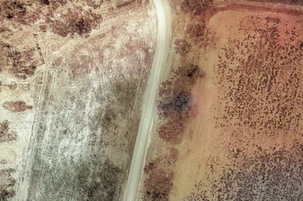 カントリーブッシュの風景 高視野のドローンの空中 カラー画像を介してカーブ未舗装の道路 — ストック写真