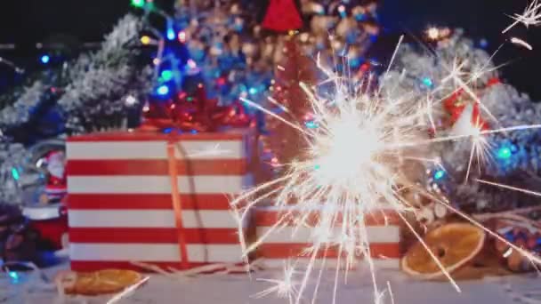 Luzes de bengala queimar brilhantemente contra o fundo de presentes e decoração de Ano Novo. — Vídeo de Stock