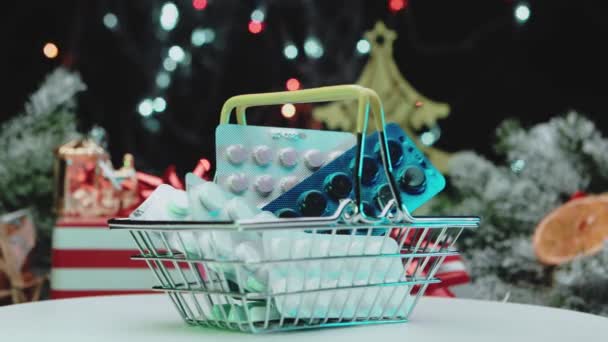 Pastillas en un carrito de compras en miniatura para el año nuevo y la Navidad. Concepto de compra píldoras. — Vídeo de stock