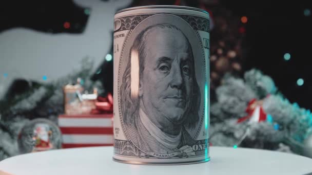 Hucha en forma de billete de cien dólares en el fondo de las luces de Navidad. — Vídeo de stock