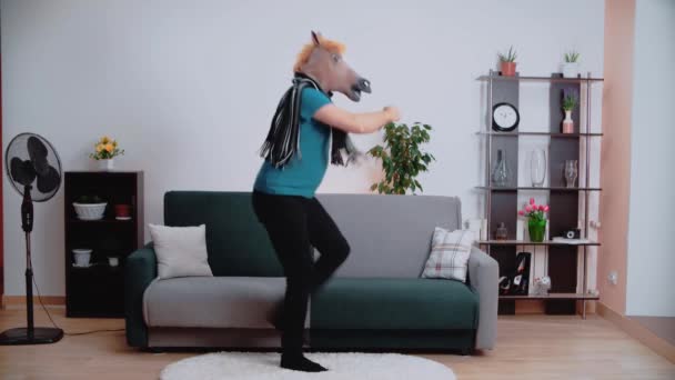 Een man met een paardenmasker danst vrolijk in de kamer.. — Stockvideo