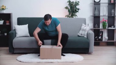 Adam paketi açar ve içindekilerle çok mutlu olur..