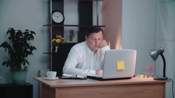 Pekerja kantor sedang tidur. Seorang pria dalam kemeja duduk di kursi, tidur di tempat kerja di kantor. — Stok Video