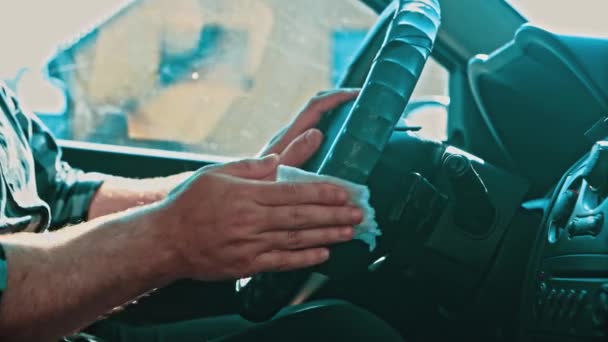 Primo piano - una mano che pulisce un panno umido per disinfettare il volante di un'auto. — Video Stock