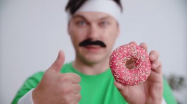 Erkek sporcu elinde donut tutuyor. Sağlıklı gıda kavramı..
