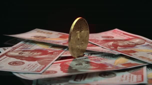 Primo piano di Bitcoin che ruota su banconote da cento dollari. — Video Stock