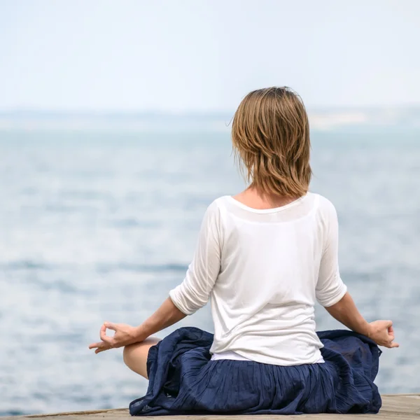 Frau meditiert am Meer — Stockfoto