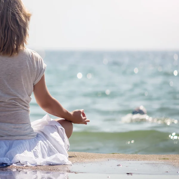 Frau meditiert am Meer — Stockfoto