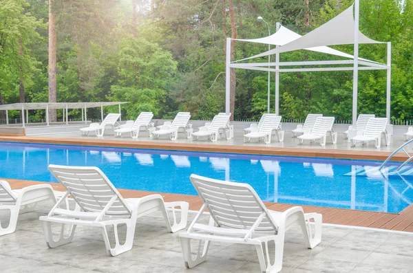 Piscina limpia y silla de descanso vacía —  Fotos de Stock