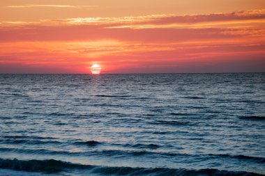 denizin üzerinde yükselen güneş