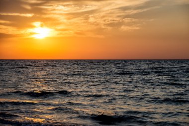 denizin üzerinde yükselen güneş