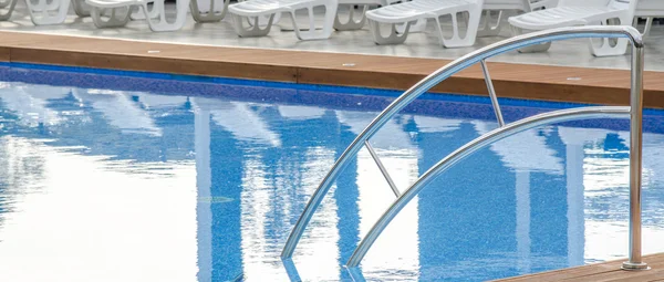 Sauberes Schwimmbad und leerer Liegestuhl — Stockfoto