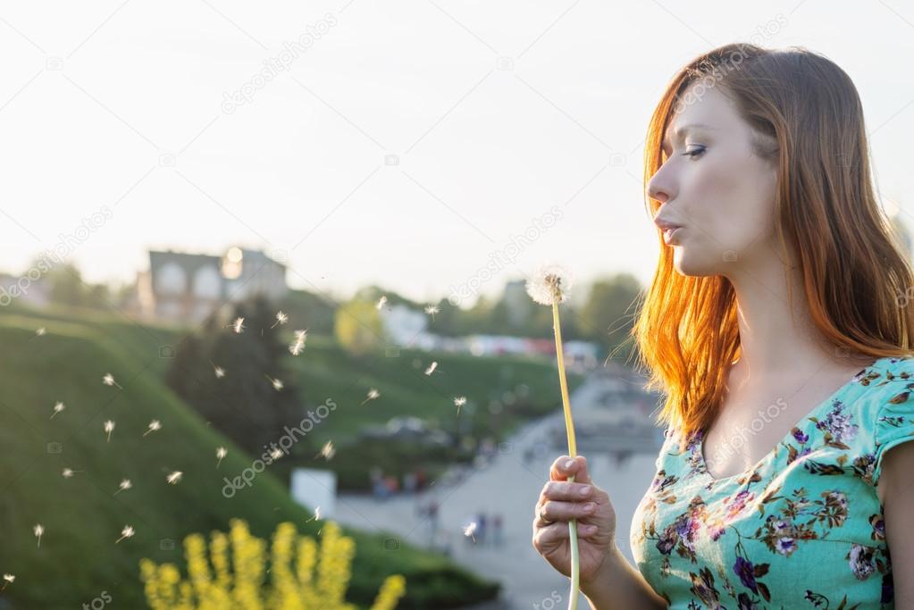 Girl blowing dandelion