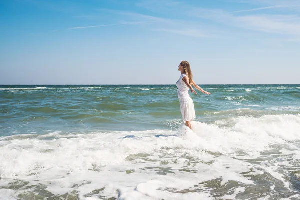 Flicka står vid stranden — Stockfoto