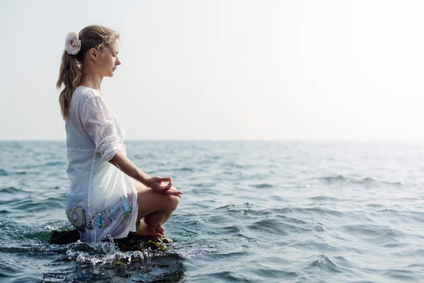 Frau meditiert am Meer — Stockfoto