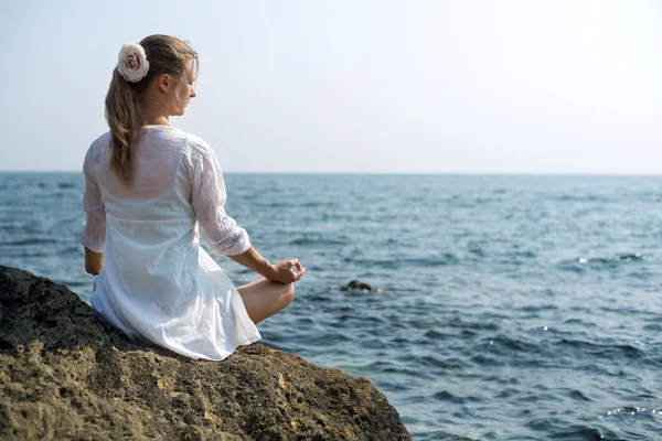 Kvinna mediterar vid havet — Stockfoto