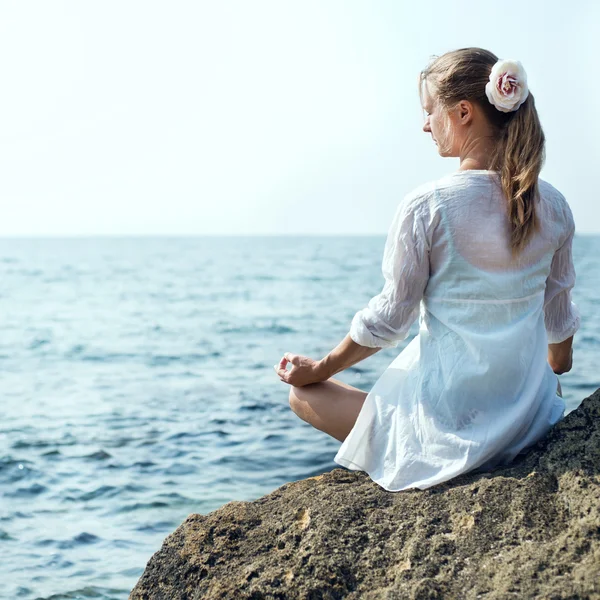 Frau meditiert am Meer — Stockfoto