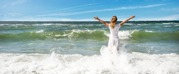 Женщина в летнем платье, стоящая на море — стоковое фото