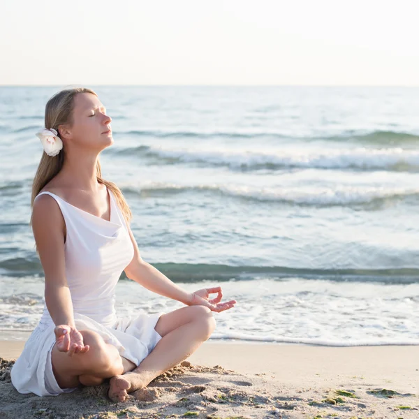 Fiatal nő meditáció a strandon — Stock Fotó