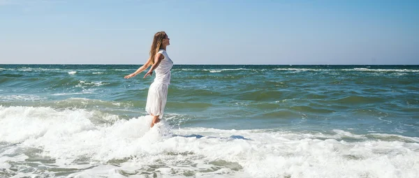 Flicka står vid stranden — Stockfoto