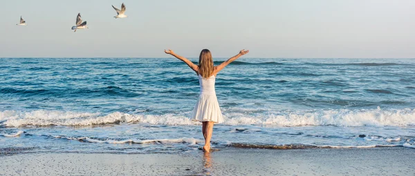 Девушка, стоящая на пляже — стоковое фото