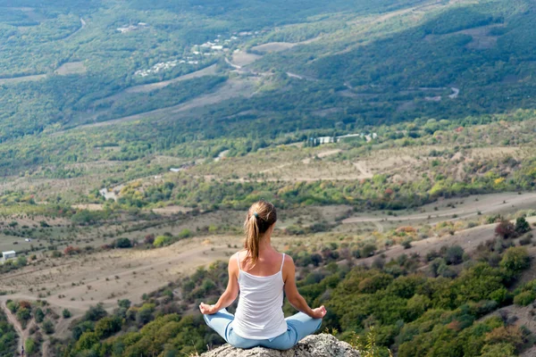 Nainen meditoi vuorilla — kuvapankkivalokuva