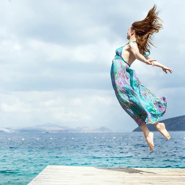 年轻女子在海滩上跳跃 — 图库照片
