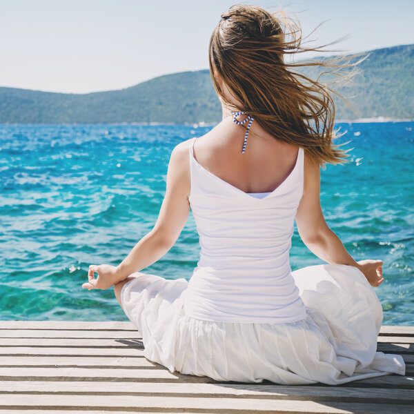 Woman meditating at the sea