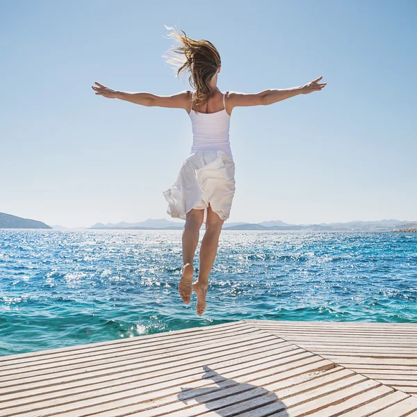 Junge Frau springt am Strand — Stockfoto