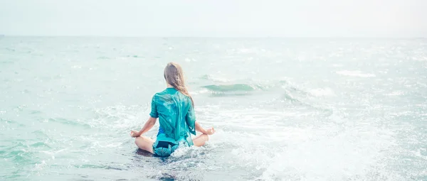 Mujer meditando en el mar — Foto de Stock