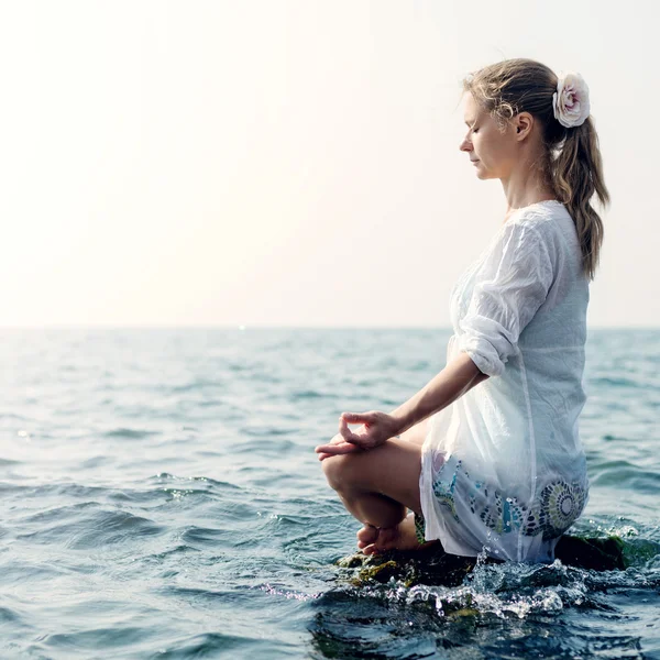 Женщина медитирует у моря — стоковое фото