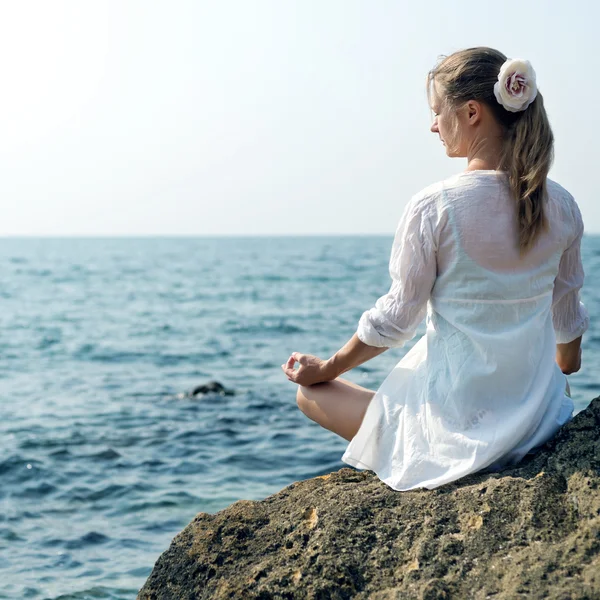 Frau meditiert am Meer — Stockfoto