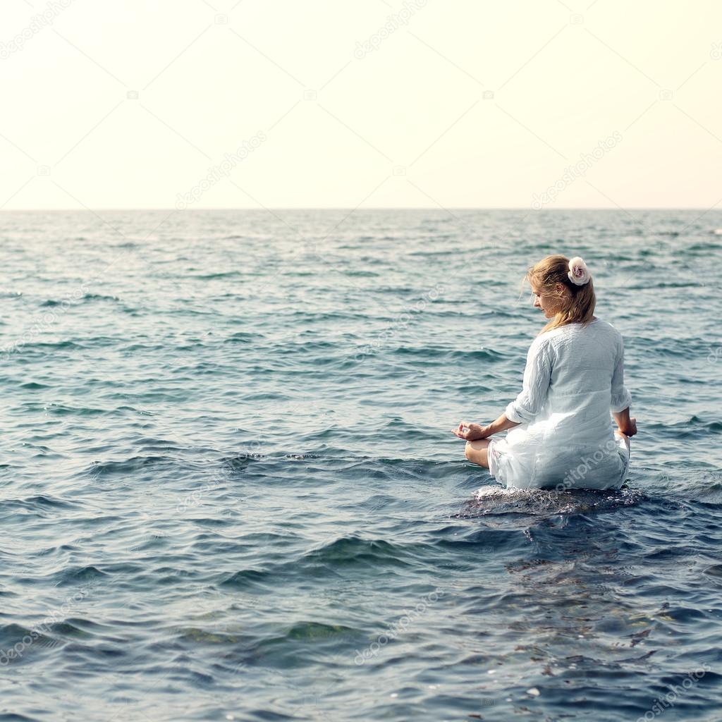 Woman meditating at the sea