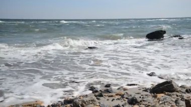 Dalgalar, kum ve taşları ile deniz maliyet