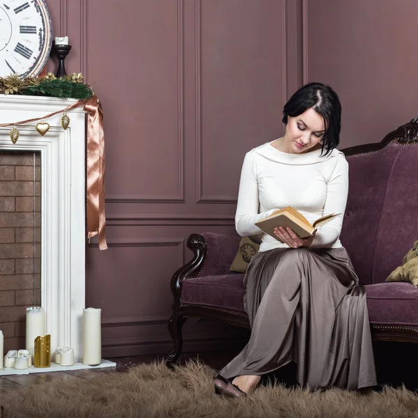 Woman reading book at sofa — Stock Photo, Image