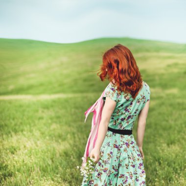 Yeşil çimenlerin üzerinde duran kız