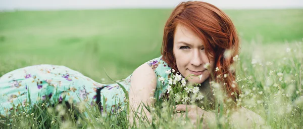 Mädchen liegt im Blumenfeld — Stockfoto