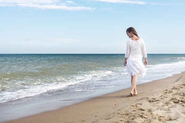 Mulher em vestido de verão em pé em um mar — Fotografia de Stock