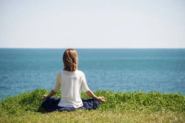 Kobieta medytująca nad morzem — Zdjęcie stockowe