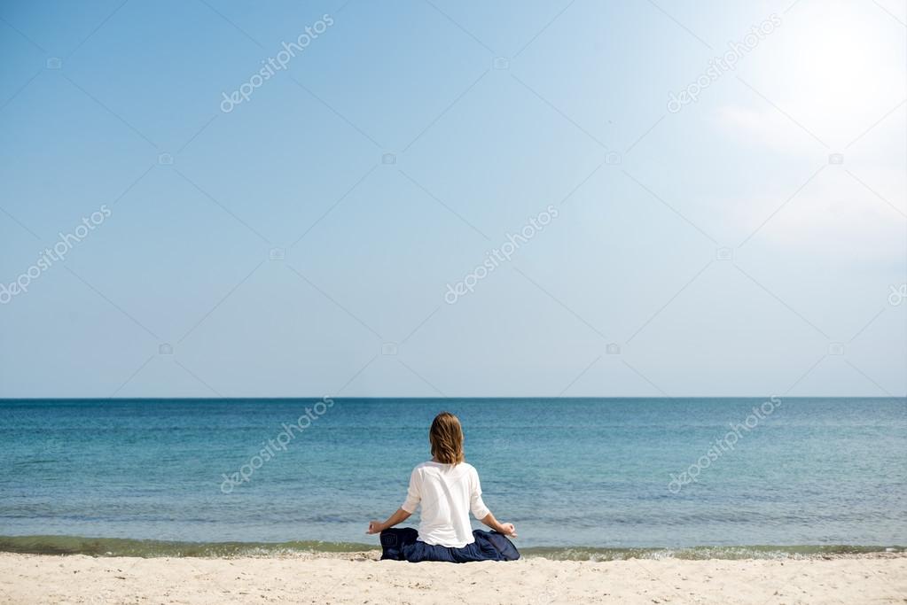 Woman meditating at the sea