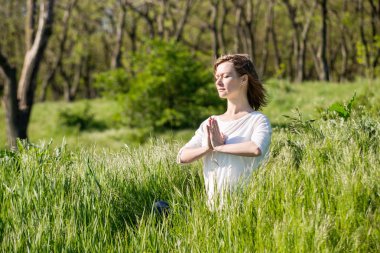 genç bir kadın parkta meditasyon