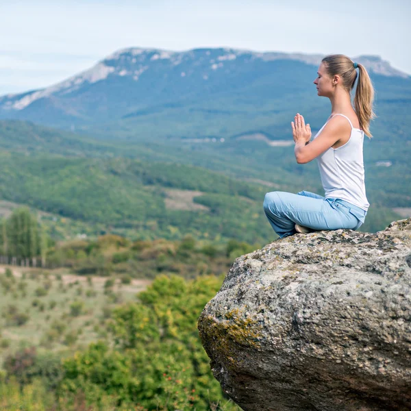 Nainen meditoi vuorilla — kuvapankkivalokuva