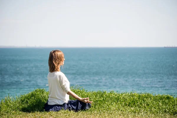 Vrouw mediterend aan zee — Stockfoto