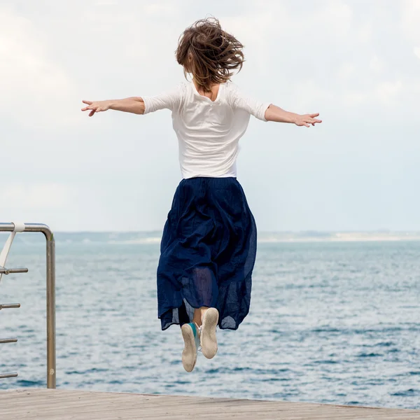 Jonge vrouw springen op het strand — Stockfoto