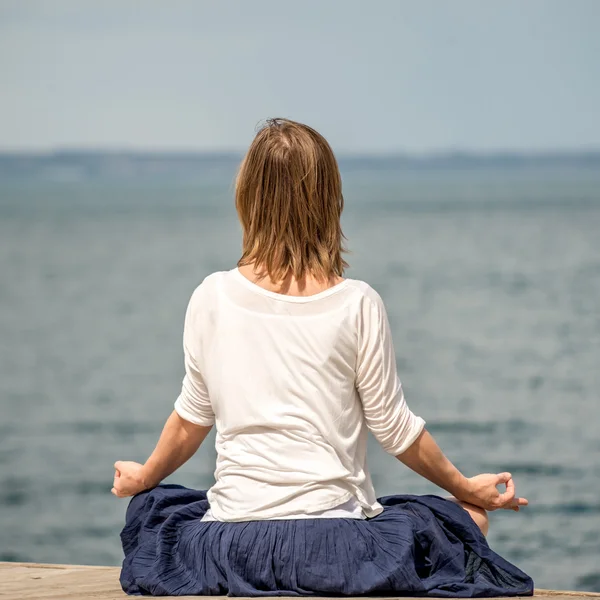 Mulher meditando no mar — Fotografia de Stock