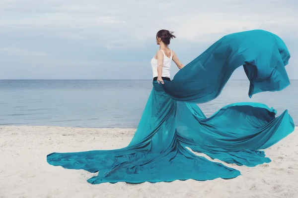 Menina bonita com tecido na praia . — Fotografia de Stock